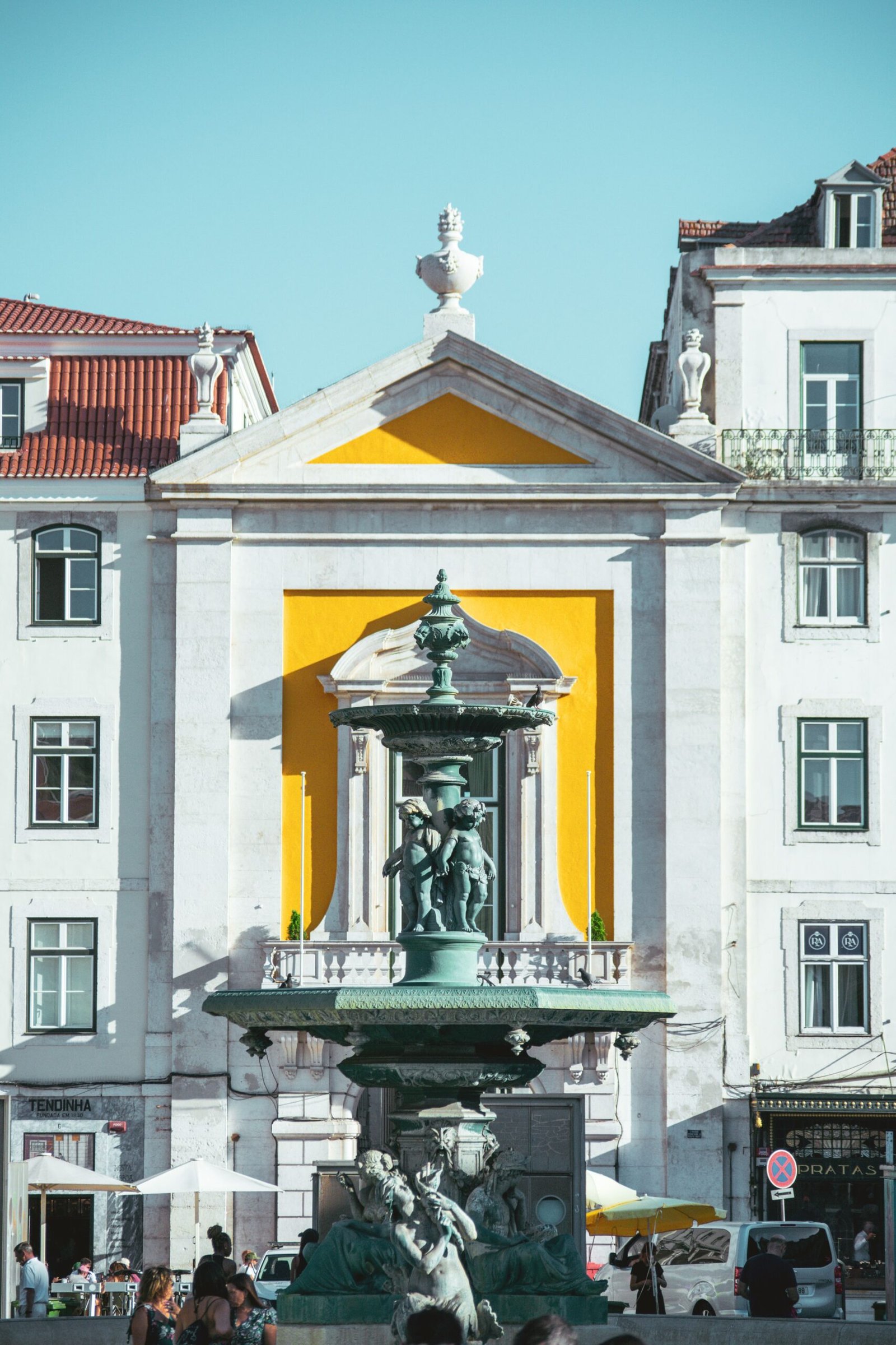 Yellow tram climbing a street in Lisbon